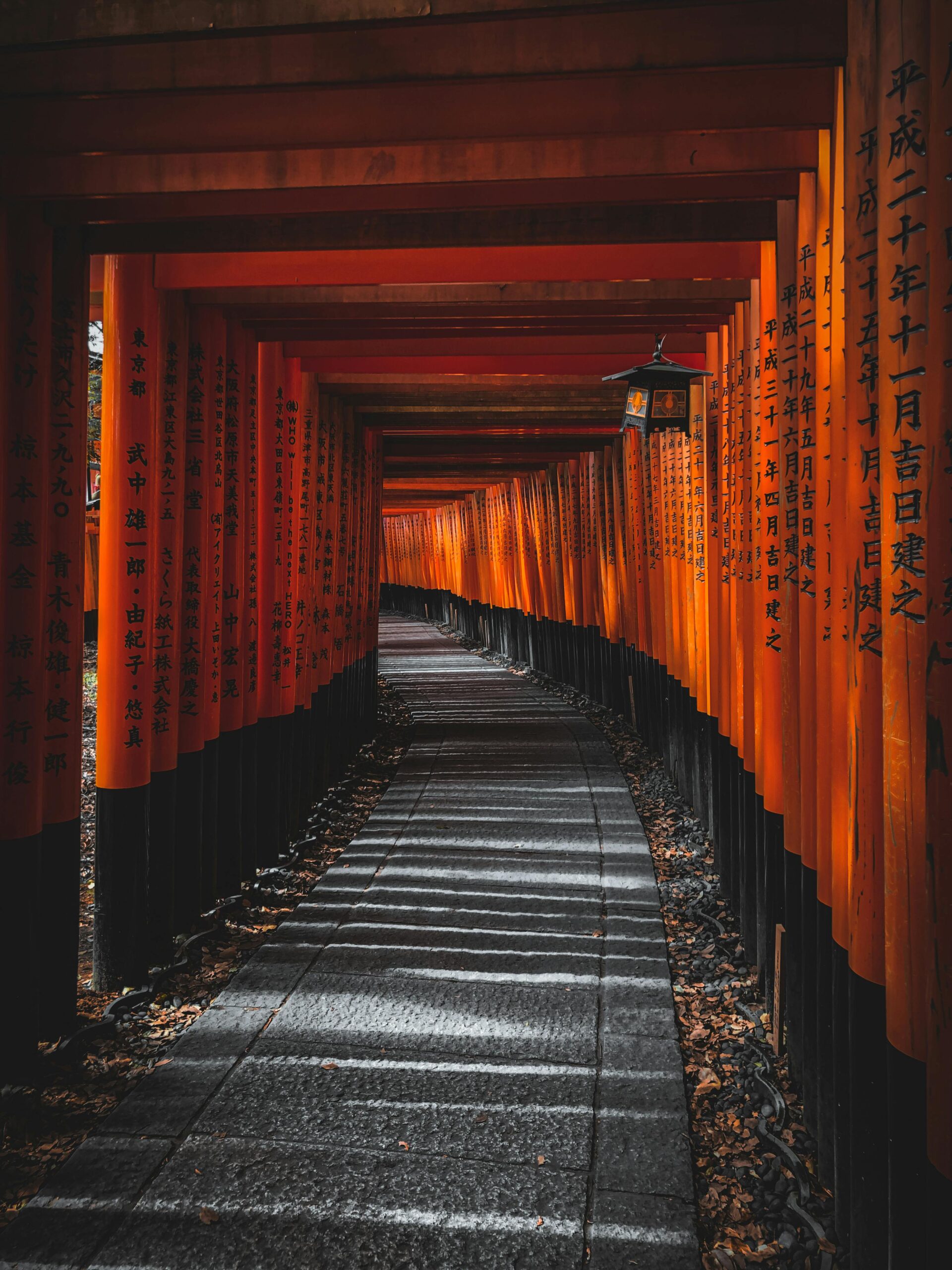 Spokojna ścieżka przez kultowe bramy torii świątyni Fushimi Inari w Kioto w Japonii.