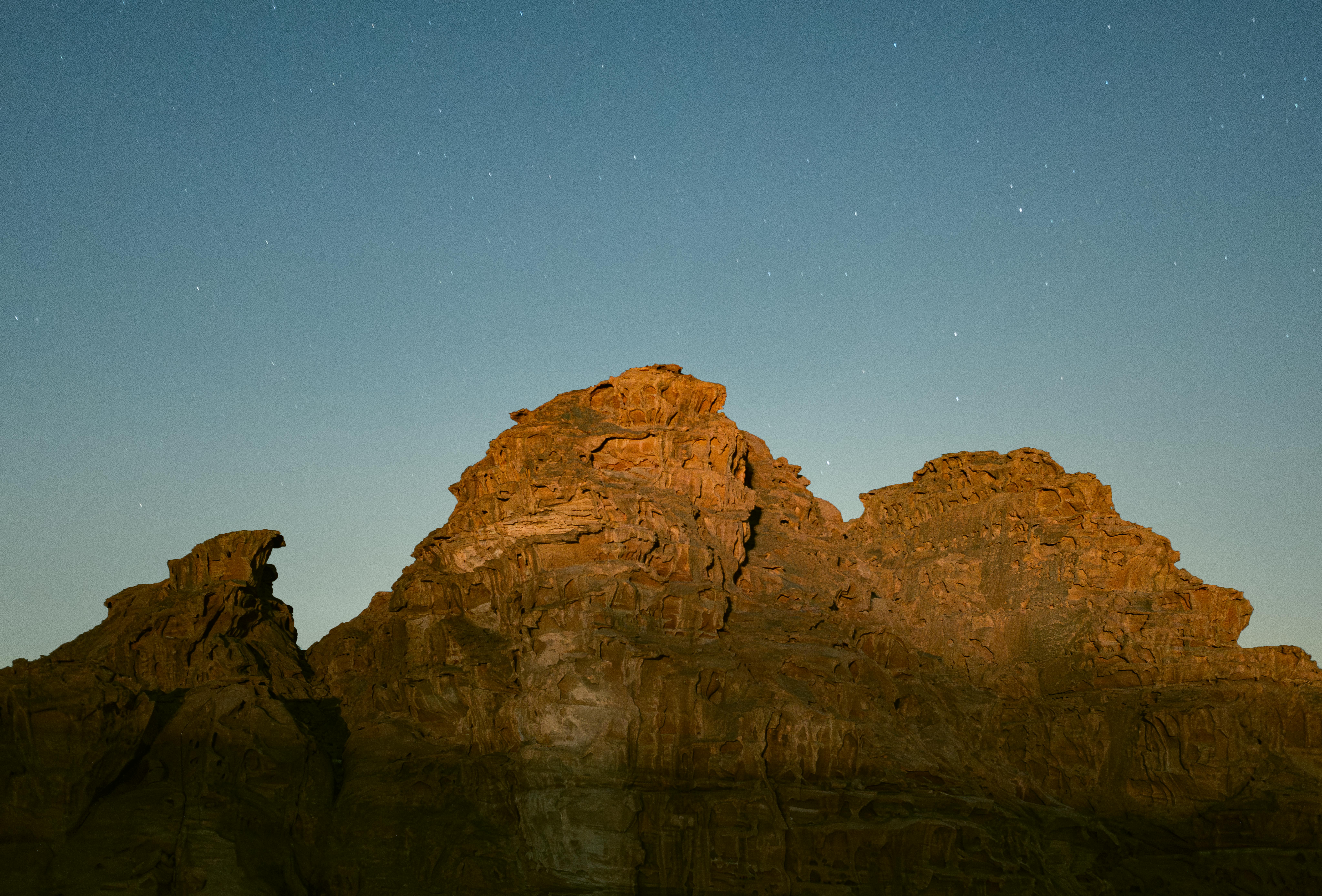 Przeglądaj majestatyczne formacje skalne Wadi Rum pod rozgwieżdżonym nocnym niebem.