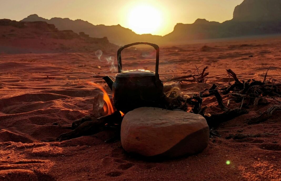 jordania Spokojny zachód słońca na pustyni z ogniskiem i czajnikiem w Wadi Rum w Jordanii.