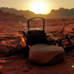 Spokojny zachód słońca na pustyni z ogniskiem i czajnikiem w Wadi Rum w Jordanii.