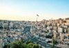 Wysoki kąt widzenia Ammanu w Jordanii z wyraźną linią horyzontu i wyraźną flagą pod czystym niebem.