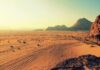 Odkryj oszałamiające piękno jałowego pustynnego krajobrazu Wadi Rum, skąpanego w ciepłych barwach zachodu słońca.