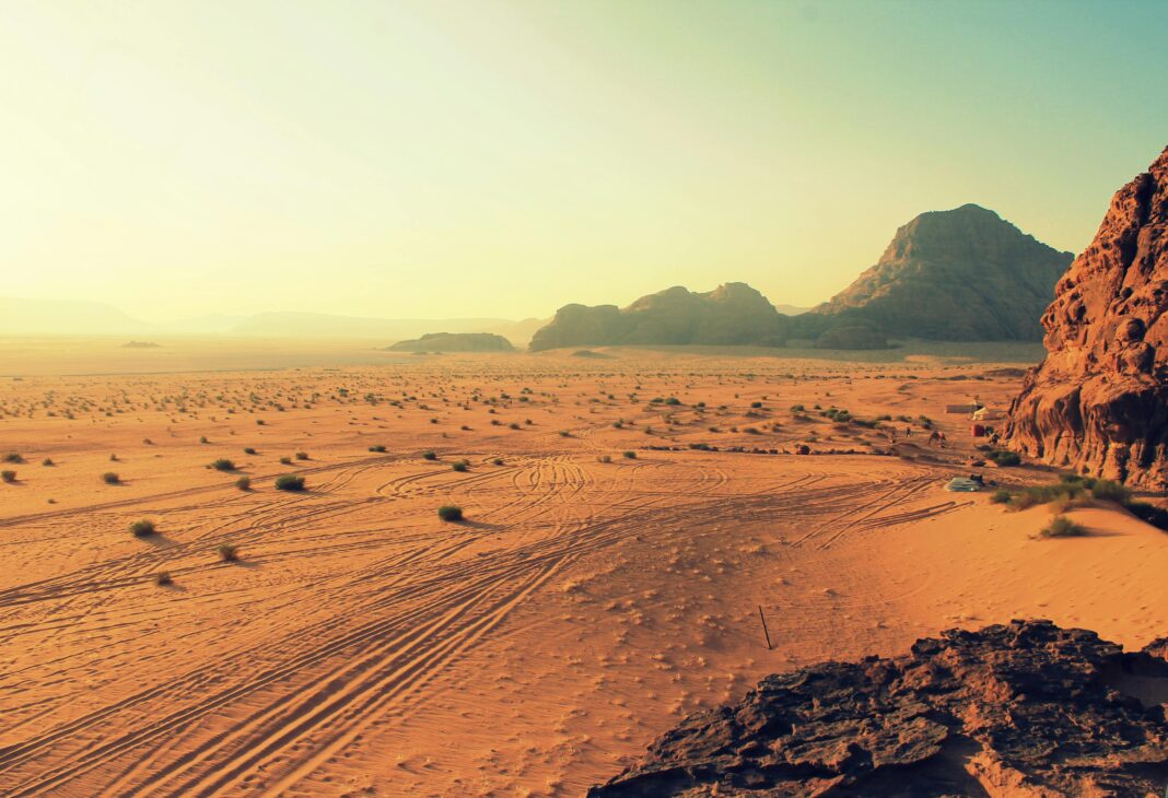 jordania Odkryj oszałamiające piękno jałowego pustynnego krajobrazu Wadi Rum, skąpanego w ciepłych barwach zachodu słońca.
