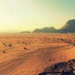 Petra nocą – magiczne doświadczenie w Jordanii Odkryj oszałamiające piękno jałowego pustynnego krajobrazu Wadi Rum, skąpanego w ciepłych barwach zachodu słońca.