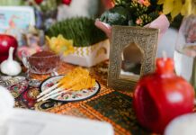 Kazachstan z lotu ptaka: Niezapomniane widoki z drona Tradycyjne nakrycie stołu Haft-sin dla Nowruz ze świątecznymi dekoracjami i symbolicznymi przedmiotami w pomieszczeniu.