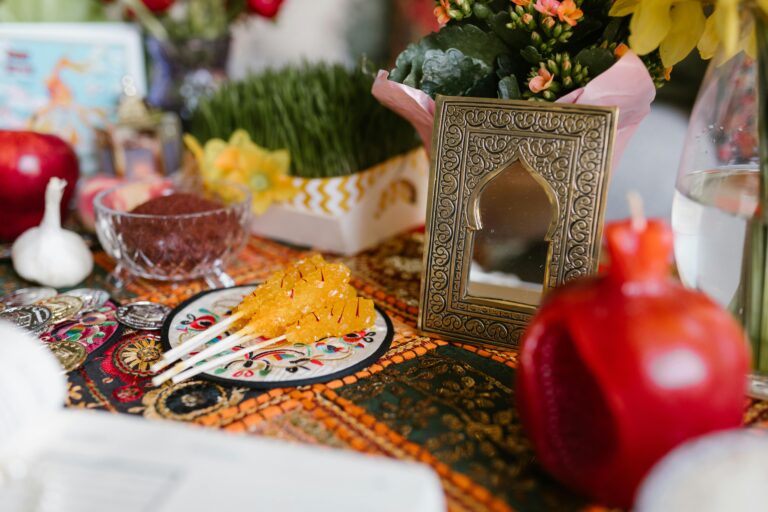 Tradycyjne nakrycie stołu Haft-sin dla Nowruz ze świątecznymi dekoracjami i symbolicznymi przedmiotami w pomieszczeniu.