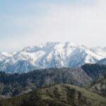 Ośnieżone pasmo górskie w Talgar w Kazachstanie, pod czystym, błękitnym niebem. 