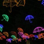 Żywe, oświetlone neonami parasole wiszące na nocnym pokazie na świeżym powietrzu.