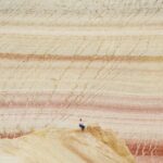 Osoba badająca unikalne formacje skalne na suchej pustyni Bozzhyra w Kazachstanie.