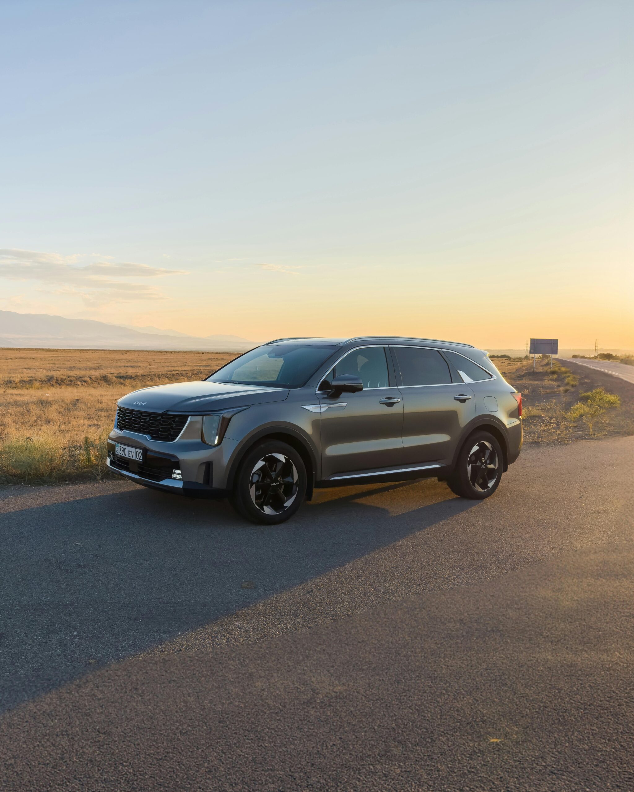 Elegancki SUV na tle oszałamiającego zachodu słońca na bezludnej drodze, idealny do motywów podróżniczych.