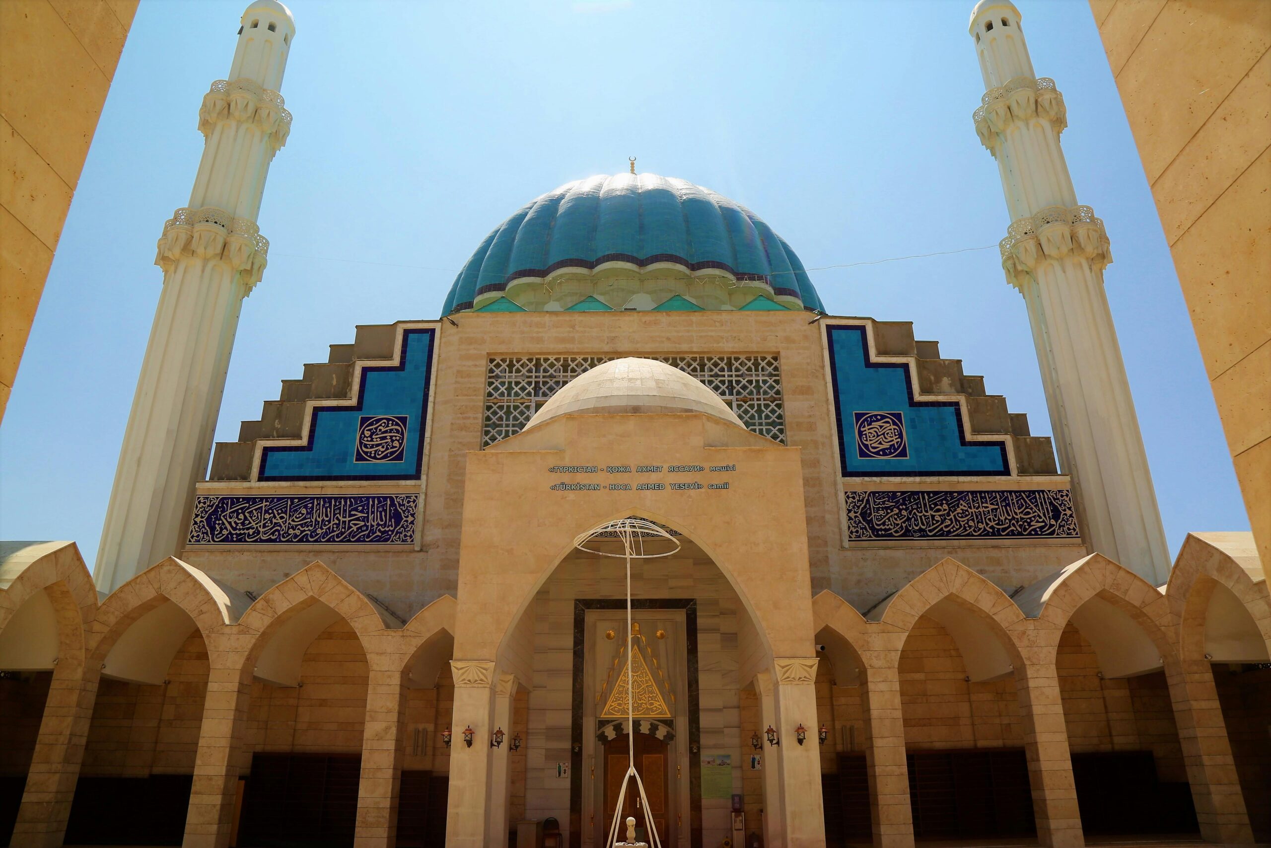 Oszałamiający widok na meczet w Turkstanie, ukazujący jego wielką niebieską kopułę i skomplikowaną architekturę.