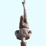 Języki w Kenii – swahili i angielski w codziennym życiu Odważny akrobata wisi do góry nogami na tle czystego nieba, pokazując siłę i równowagę w Juja w Kenii.