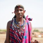 Portret członka plemienia Masajów w tradycyjnym stroju, przedstawiający dziedzictwo kulturowe Kenii.