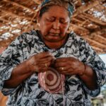 Starsza tubylcza kobieta umiejętnie wyplata kosz w Guajira w Kolumbii.