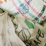 Zbliżenie worków jutowych na organiczne ziarna kawy w palarni.