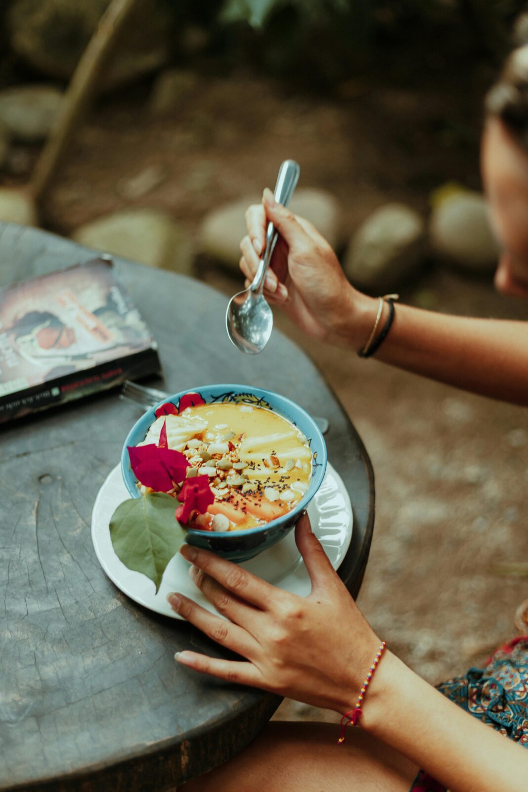 Tętniąca życiem miska śniadaniowa z owocami i kwiatami na rustykalnym stole na świeżym powietrzu w Kolumbii.