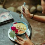 Tętniąca życiem miska śniadaniowa z owocami i kwiatami na rustykalnym stole na świeżym powietrzu w Kolumbii.