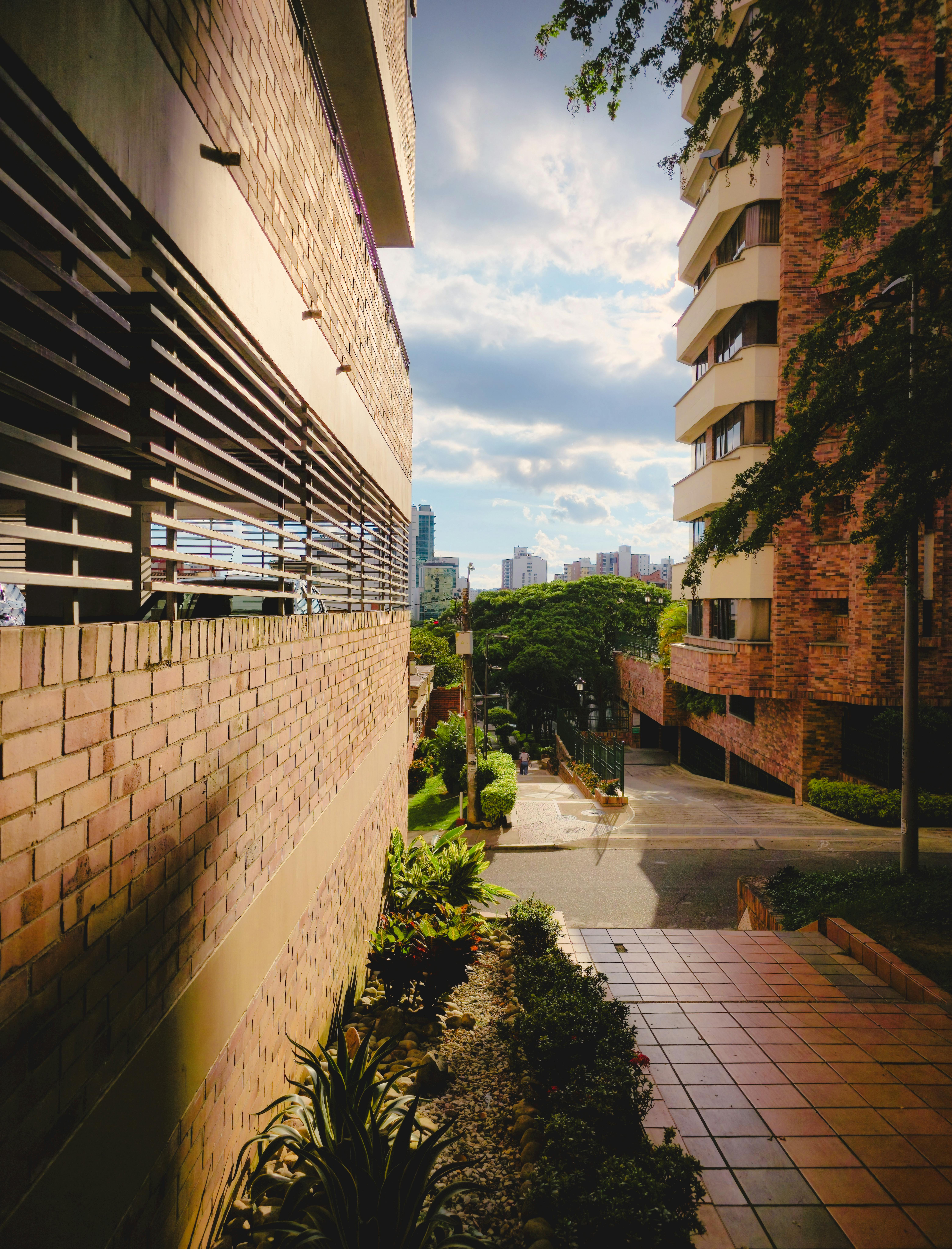 Scena miejska w Bucaramanga w Kolumbii, prezentująca nowoczesną architekturę z zielenią pod słonecznym niebem.