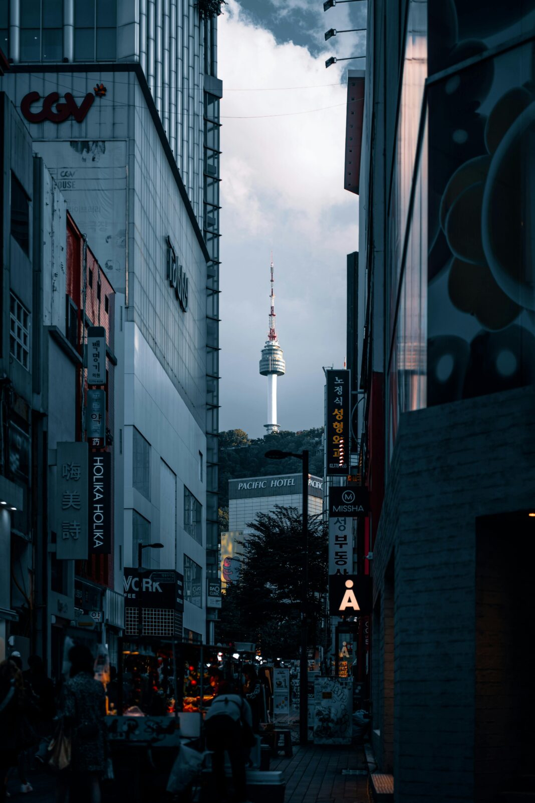 Miejski widok na tętniące życiem ulice Seulu ze słynną wieżą Namsan w tle o zmierzchu.