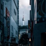Miejski widok na tętniące życiem ulice Seulu ze słynną wieżą Namsan w tle o zmierzchu.