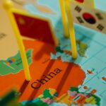 Flagi reprezentujące kraje azjatyckie na szczegółowej mapie Chin. 