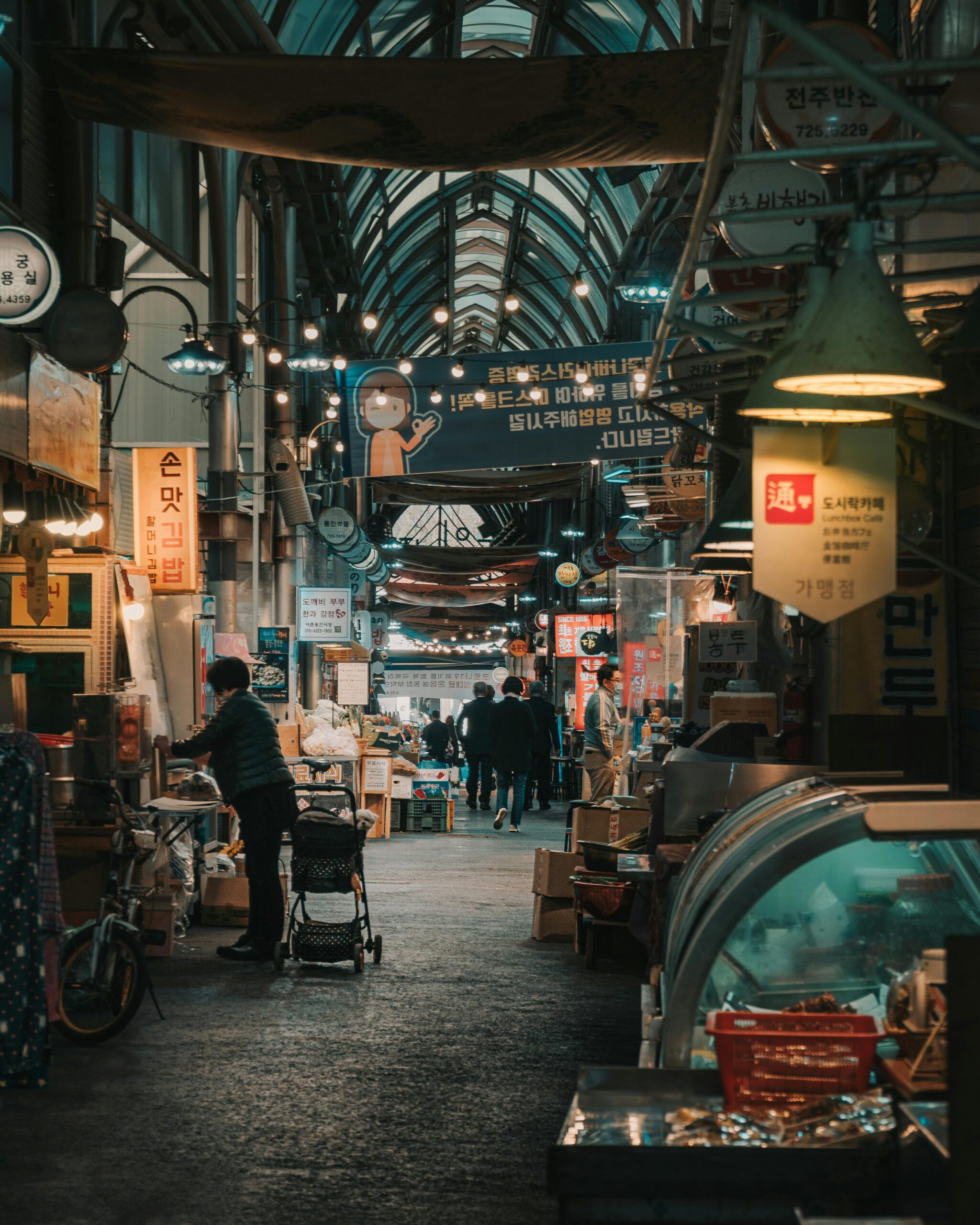 Tętniąca życiem scena na tradycyjnym targu w Seulu, prezentująca różnorodne stragany i ludzi robiących zakupy.