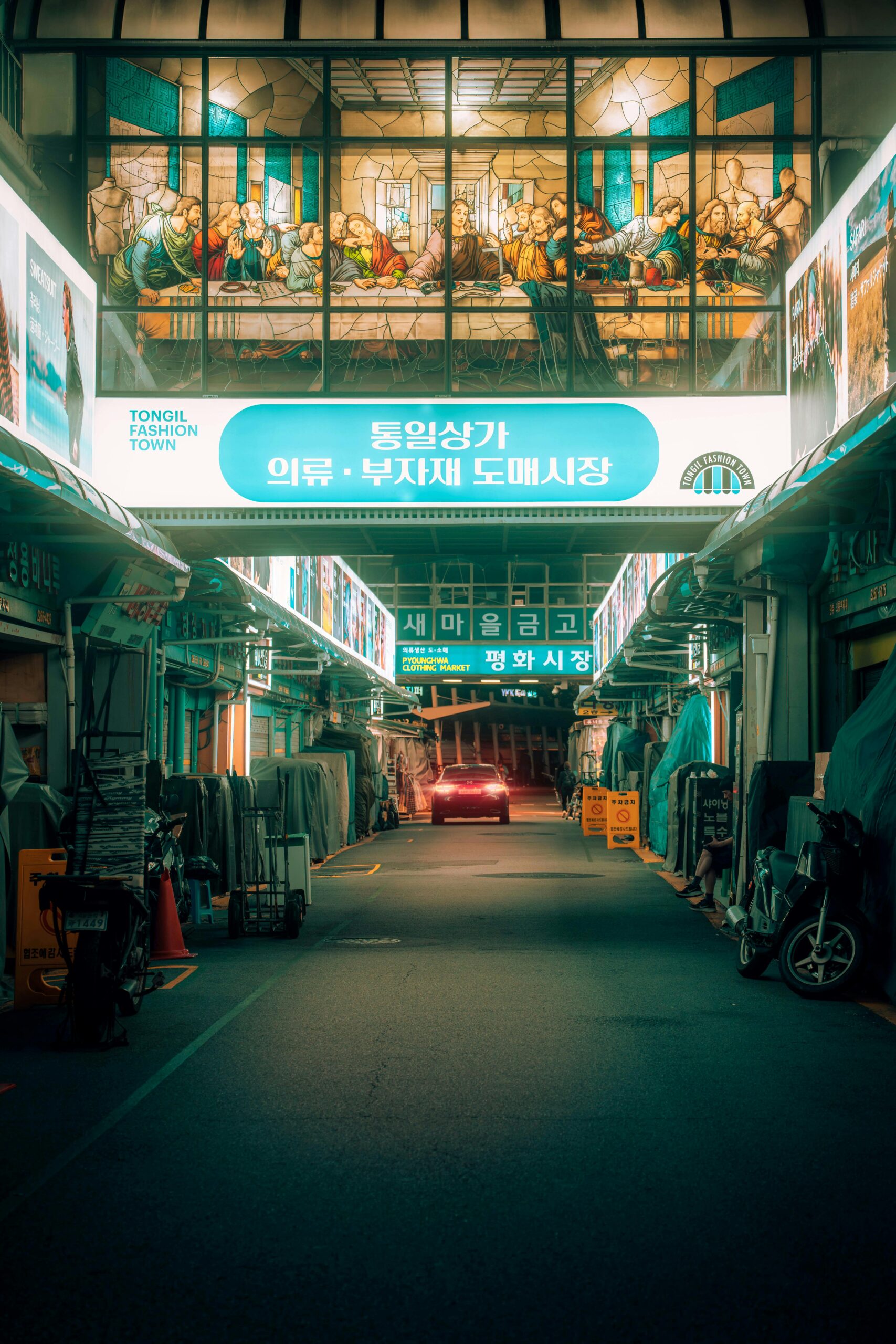 Oświetlona ulica targowa w Seulu, prezentująca żywe neony i tętniącą życiem miejską atmosferę.