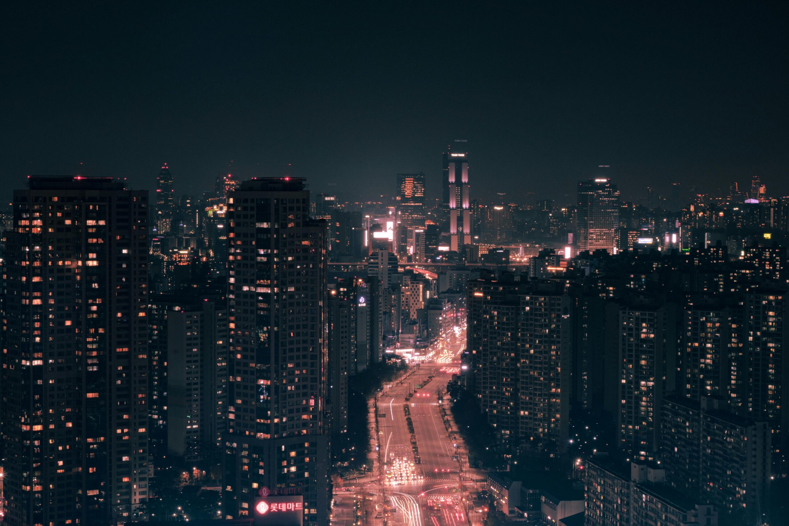 Urzekający miejski pejzaż przedstawiający oświetlone drapacze chmur na tle nocnego nieba.