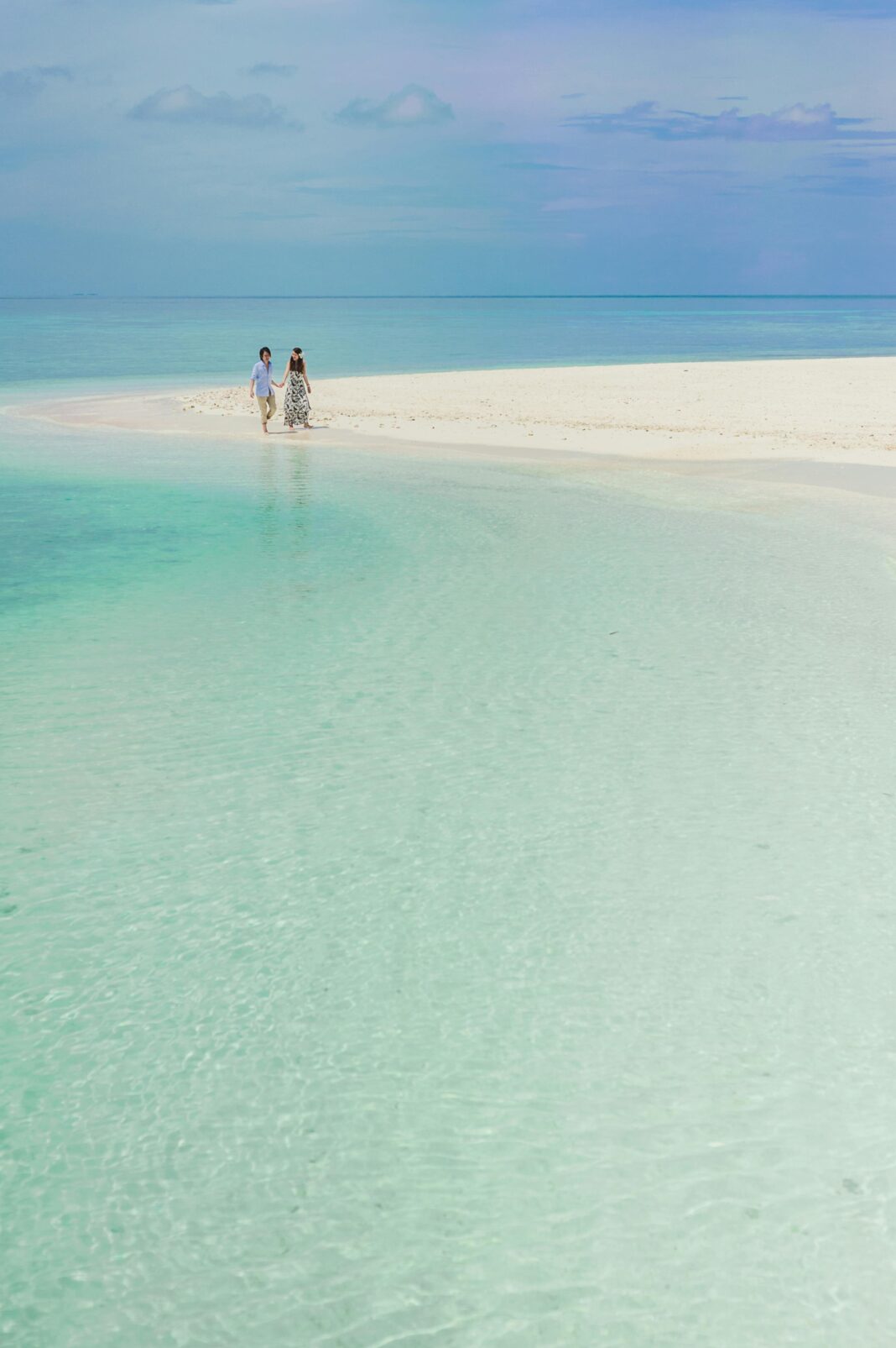 Para lubi romantyczny spacer po spokojnej, piaszczystej plaży na Malediwach.