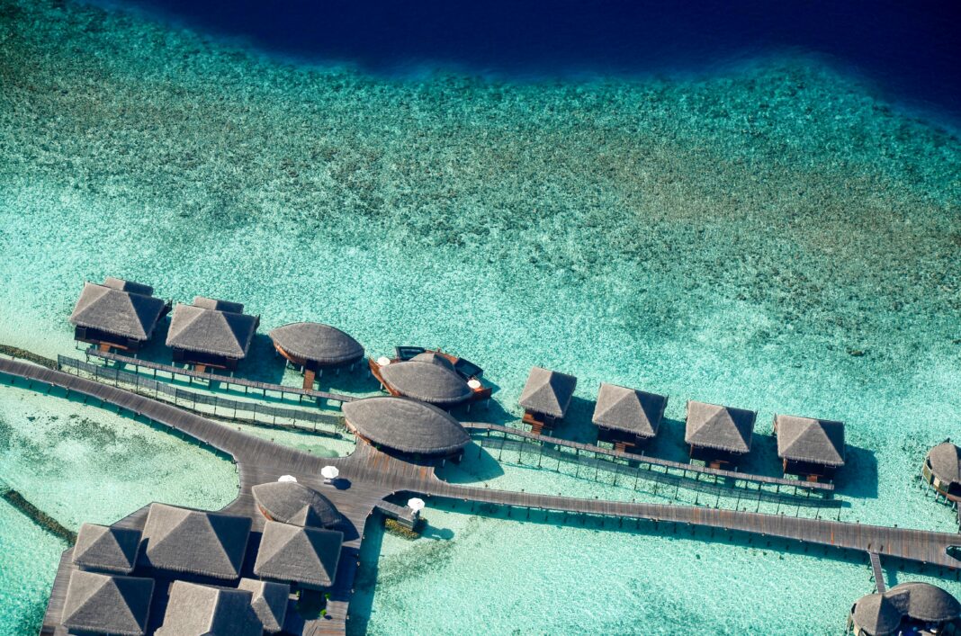 maldives Oszałamiające zdjęcia lotnicze luksusowych willi nad wodą na Malediwach, ukazujące krystalicznie czyste turkusowe wody.