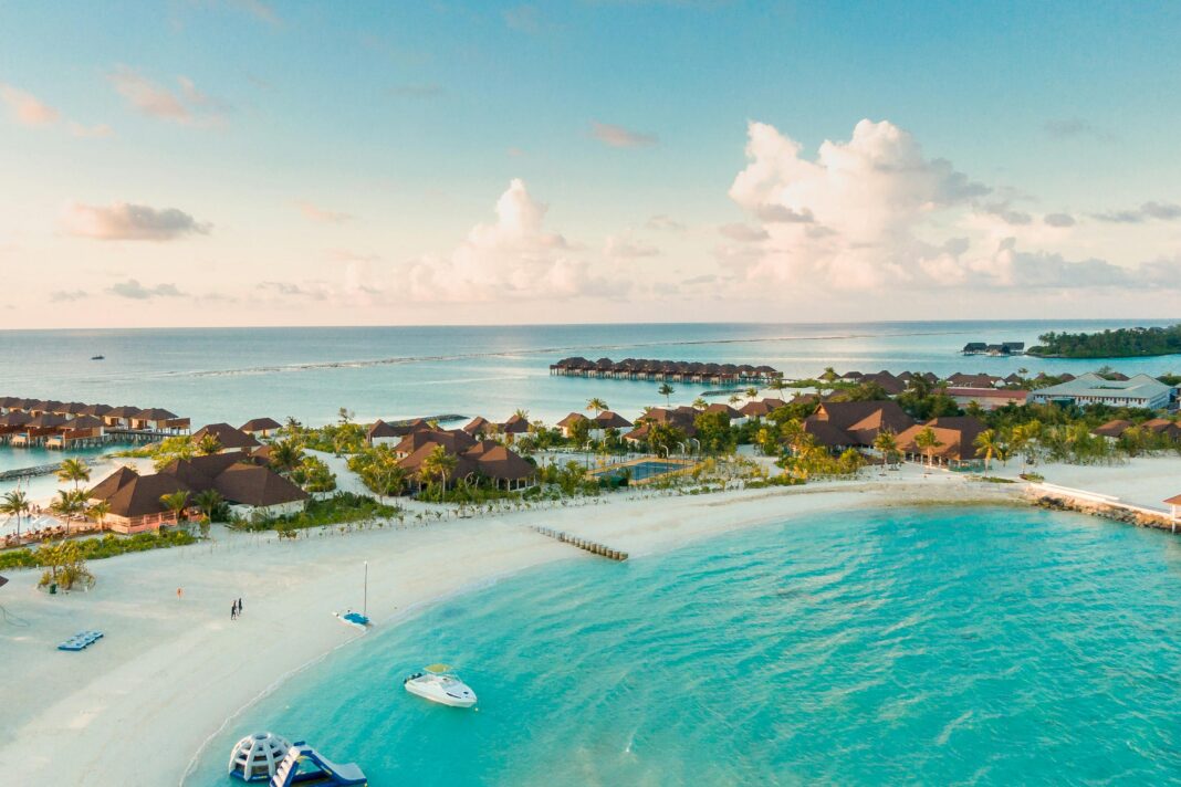 maldives Oszałamiający widok z lotu ptaka na tropikalną plażę na Malediwach z czystymi turkusowymi wodami i kurortami wzdłuż brzegu.