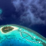 Oszałamiające zdjęcia lotnicze tropikalnego kurortu na wyspie otoczonego turkusowymi wodami na Malediwach.