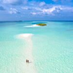 Widok z lotu ptaka na tropikalną mierzeję z turkusowymi wodami i czystym niebem, idealny na spokojne wakacje.