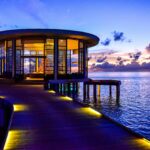 Piękny okrągły pawilon na molo z widokiem na spokojne morze o zachodzie słońca.