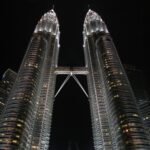 Zapierające dech w piersiach zdjęcie z niskiego kąta oświetlonych nocą Petronas Towers w Kuala Lumpur.