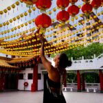 Kobieta sięga po żywe papierowe latarnie w świątyni Thean Hou w Kuala Lumpur.