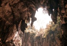 Malezyjska sztuka batiku: Tradycja i nowoczesne inspiracje Oszałamiający obraz wejścia do jaskiń Batu z gośćmi na klatce schodowej, naturalne światło oświetlające wnętrze jaskini.