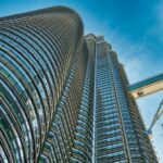 Niski kąt widzenia kultowych bliźniaczych wież Petronas w Kuala Lumpur w Malezji, na tle czystego, błękitnego nieba.