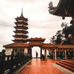 Oszałamiający widok na pagodę świątyni Chin Swee Caves o zachodzie słońca, pod którą stoi samotna postać.