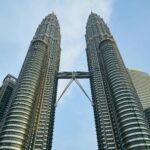 Oszałamiający widok na bliźniacze wieże Petronas na tle błękitnego nieba w Kuala Lumpur w Malezji.