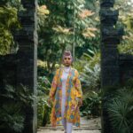 Azjatka pozuje w tętniący życiem tradycyjny sposób w bujnym ogrodzie w Kuala Lumpur.