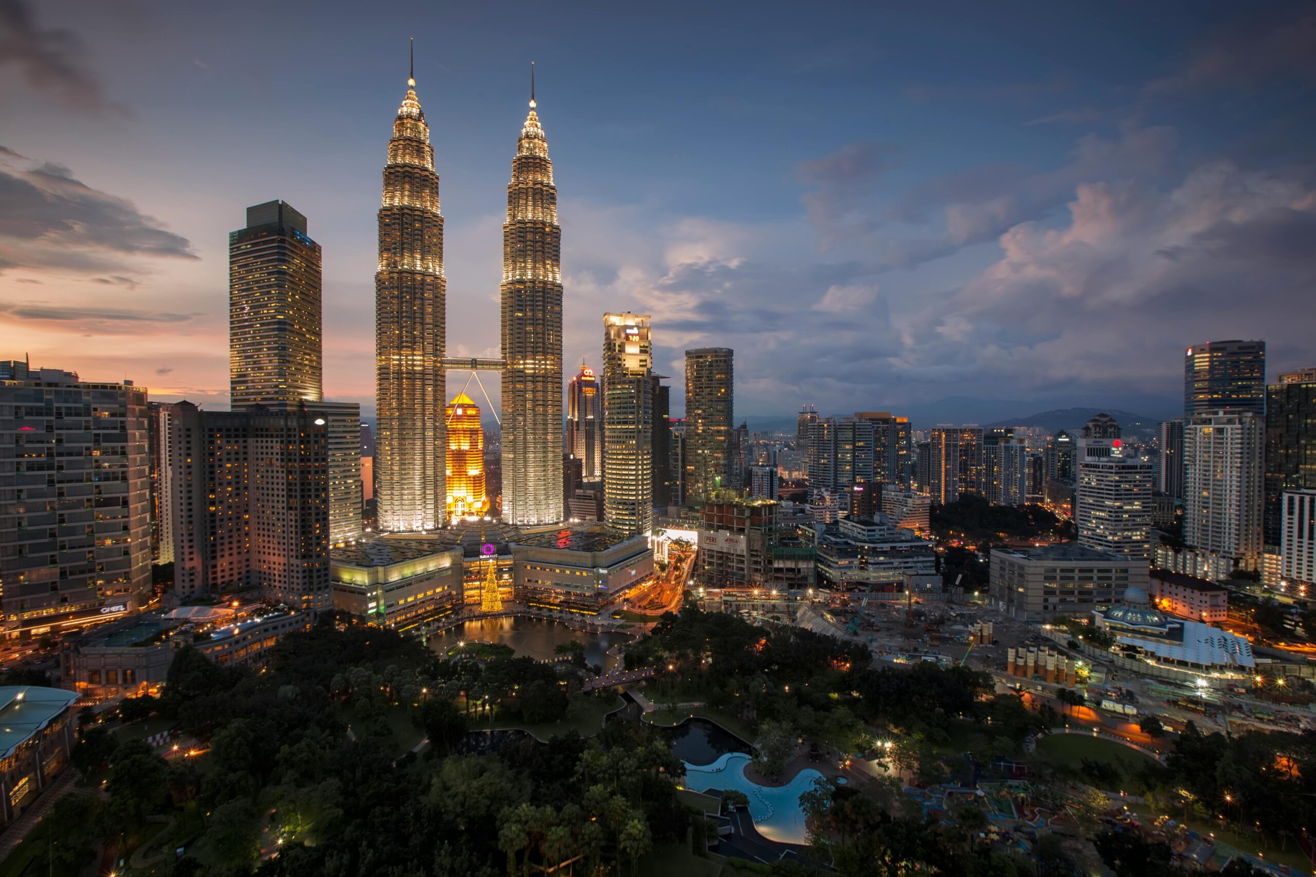 Oszałamiająca panorama Kuala Lumpur z oświetlonymi wieżami Petronas Towers o zmierzchu.