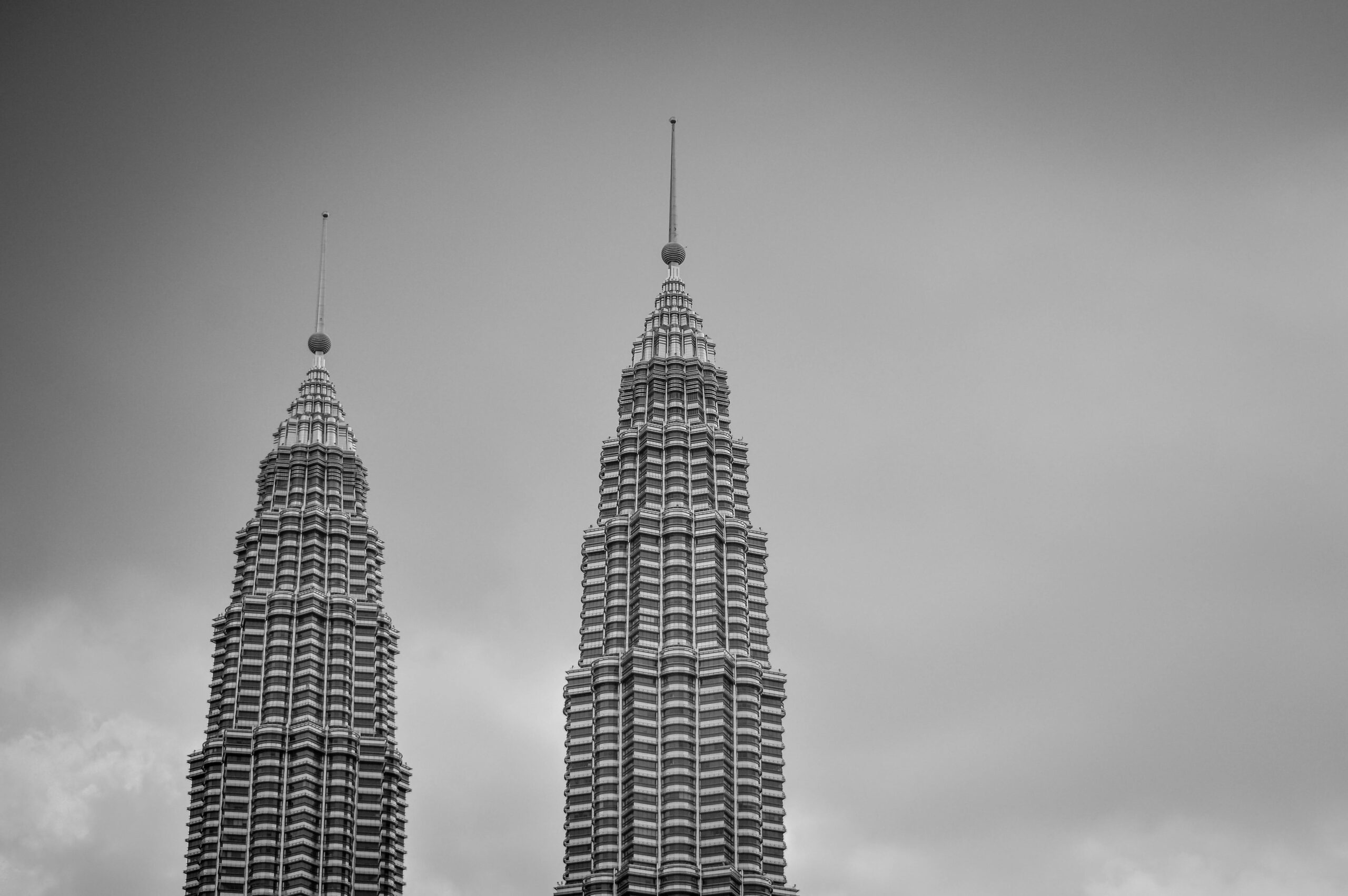 Eleganckie czarno-białe ujęcie Petronas Towers w Kuala Lumpur, płynnie ukazujące kultową architekturę.