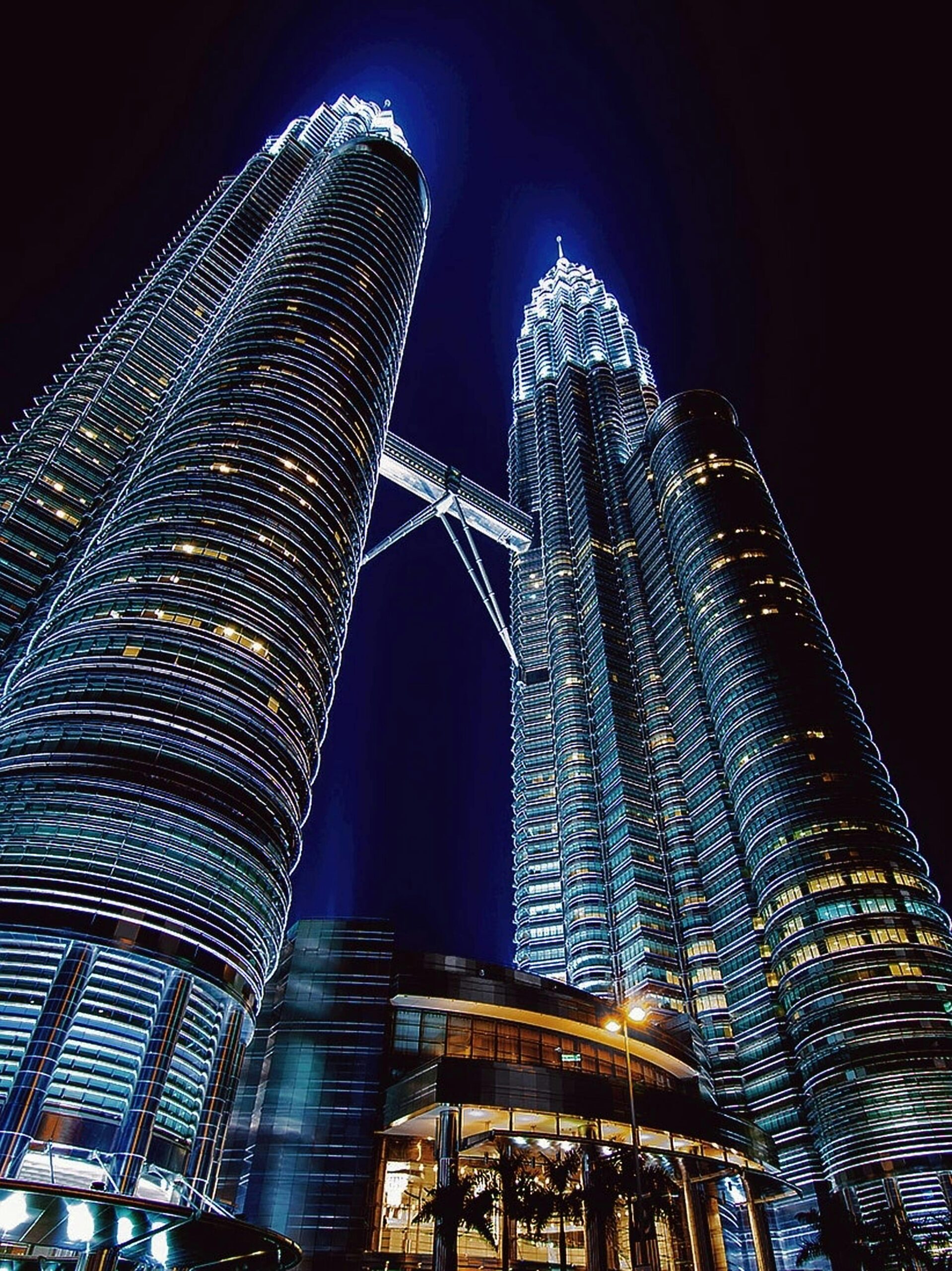 Oszałamiający nocny widok na oświetlone wieże Petronas Towers w Kuala Lumpur w Malezji.
