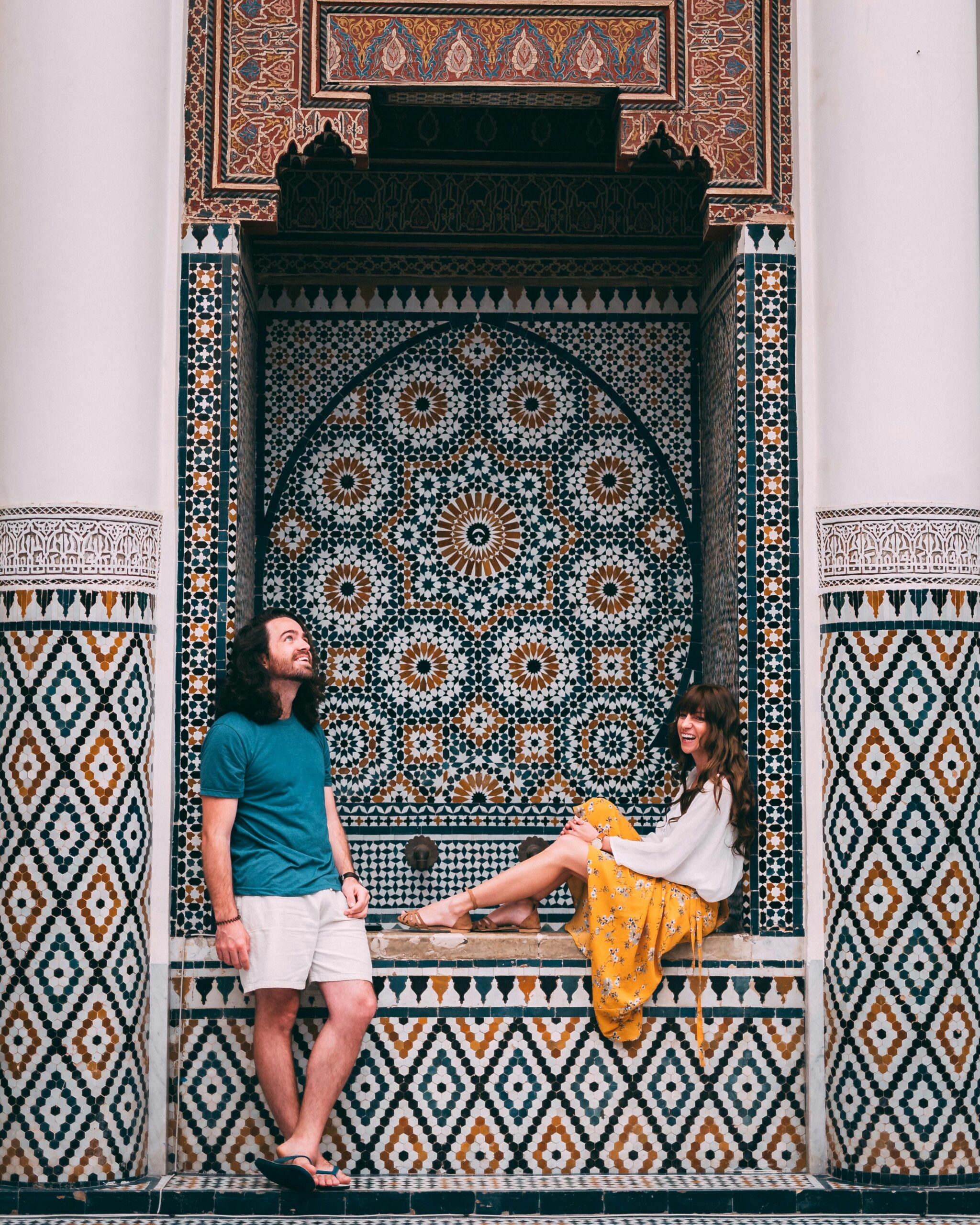 Para pozuje przy tętniących życiem marokańskich mozaikach w Marrakeszu.