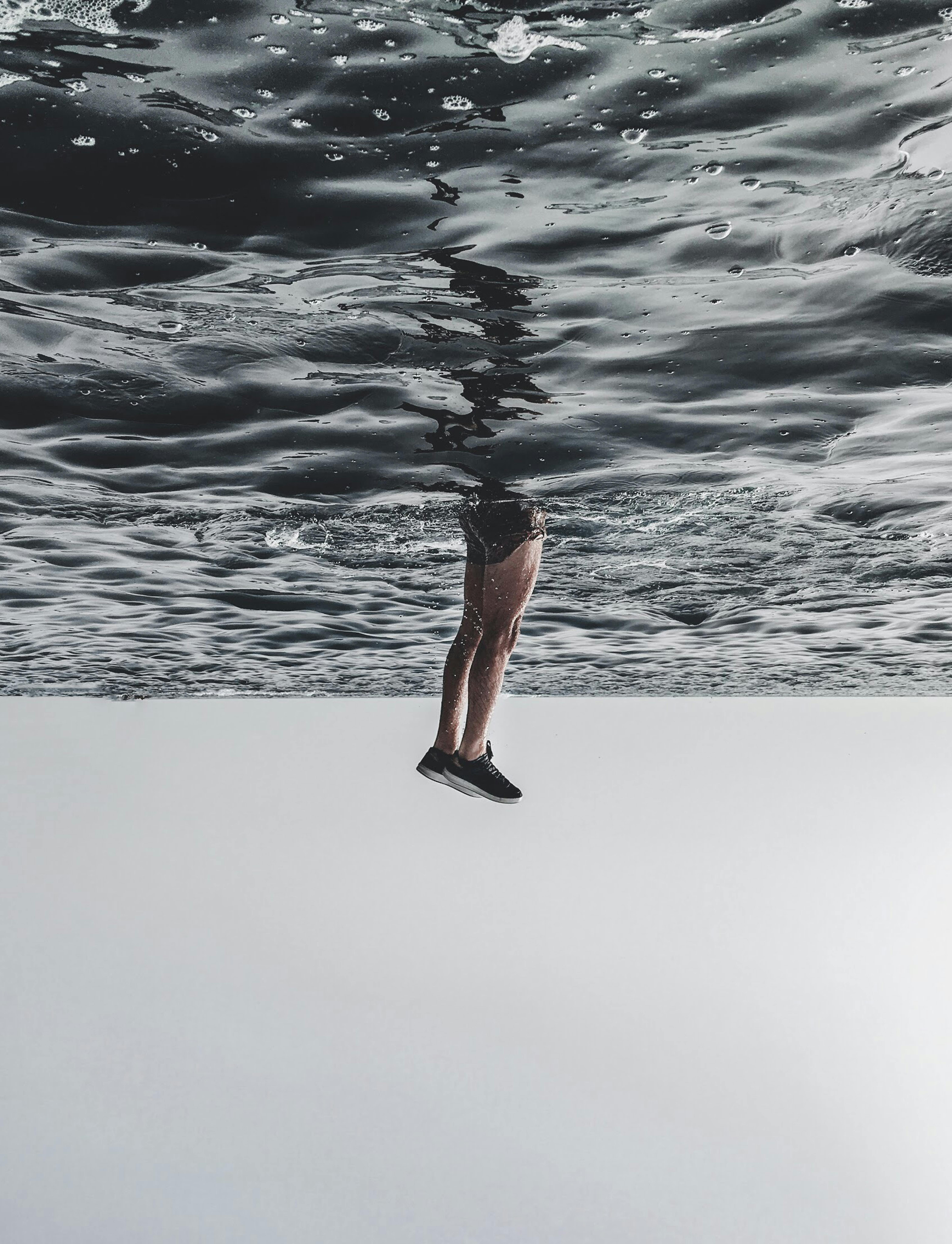 maroko Surrealistyczny obraz nóg, które wydają się chodzić po powierzchni oceanu, tworząc efekt oniryczny.