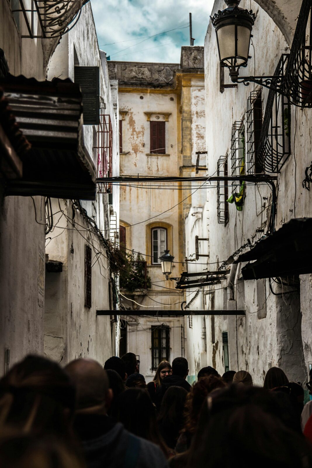 Zatłoczona wąska ulica w starej Medynie w Tetouanie z charakterystyczną marokańską architekturą.