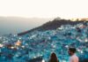 Romantyczna para trzymająca się za ręce z widokiem na Chefchaouen w Maroku o zmierzchu.