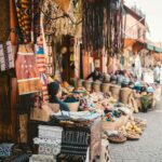 Kolorowy targ uliczny w Marakeszu w Maroku prezentujący tekstylia i rękodzieło.