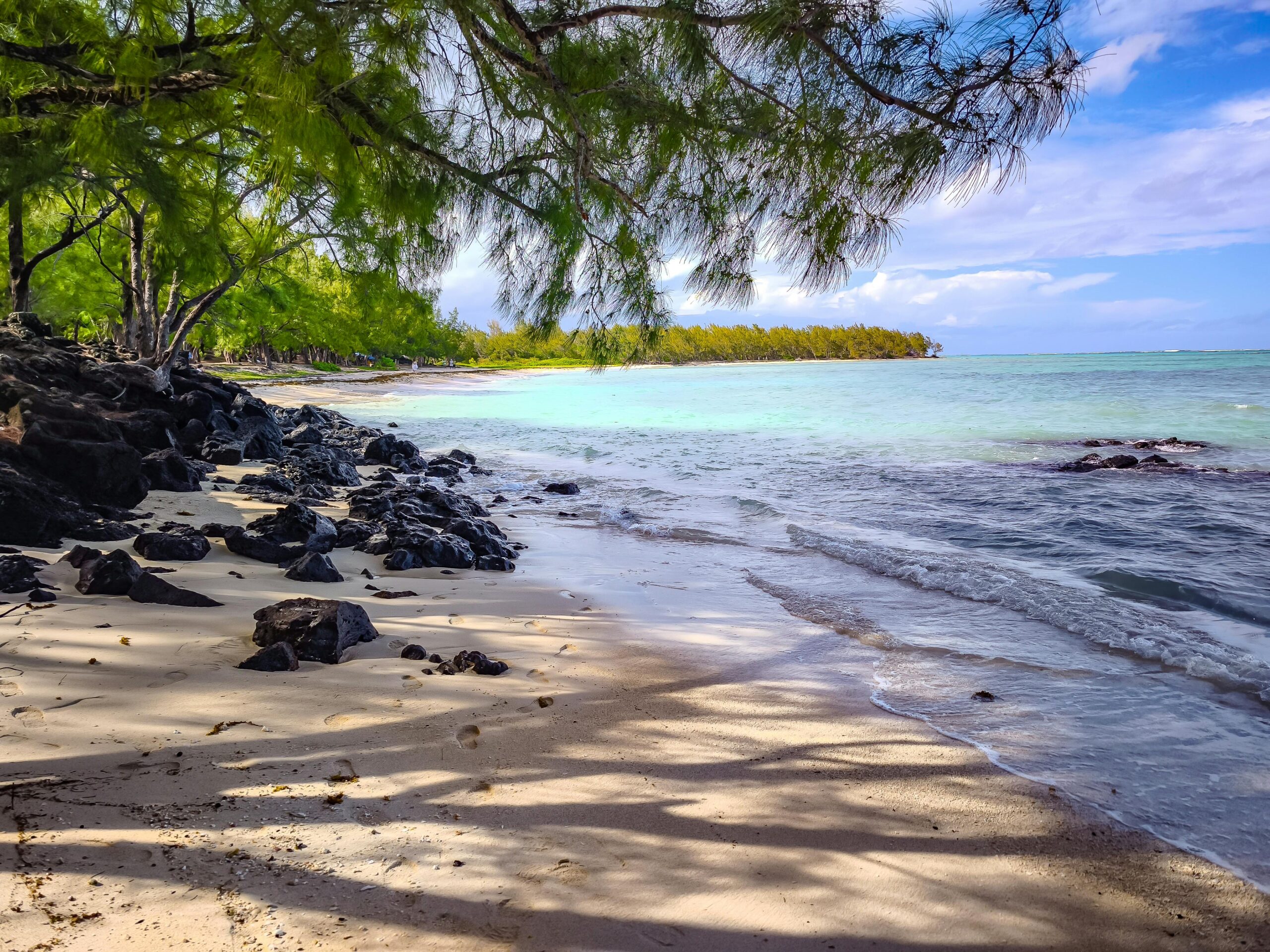 Odkryj spokojne piękno tropikalnej plaży na Mauritiusie, charakteryzującej się żywą zielenią, czystą wodą i spokojną atmosferą.
